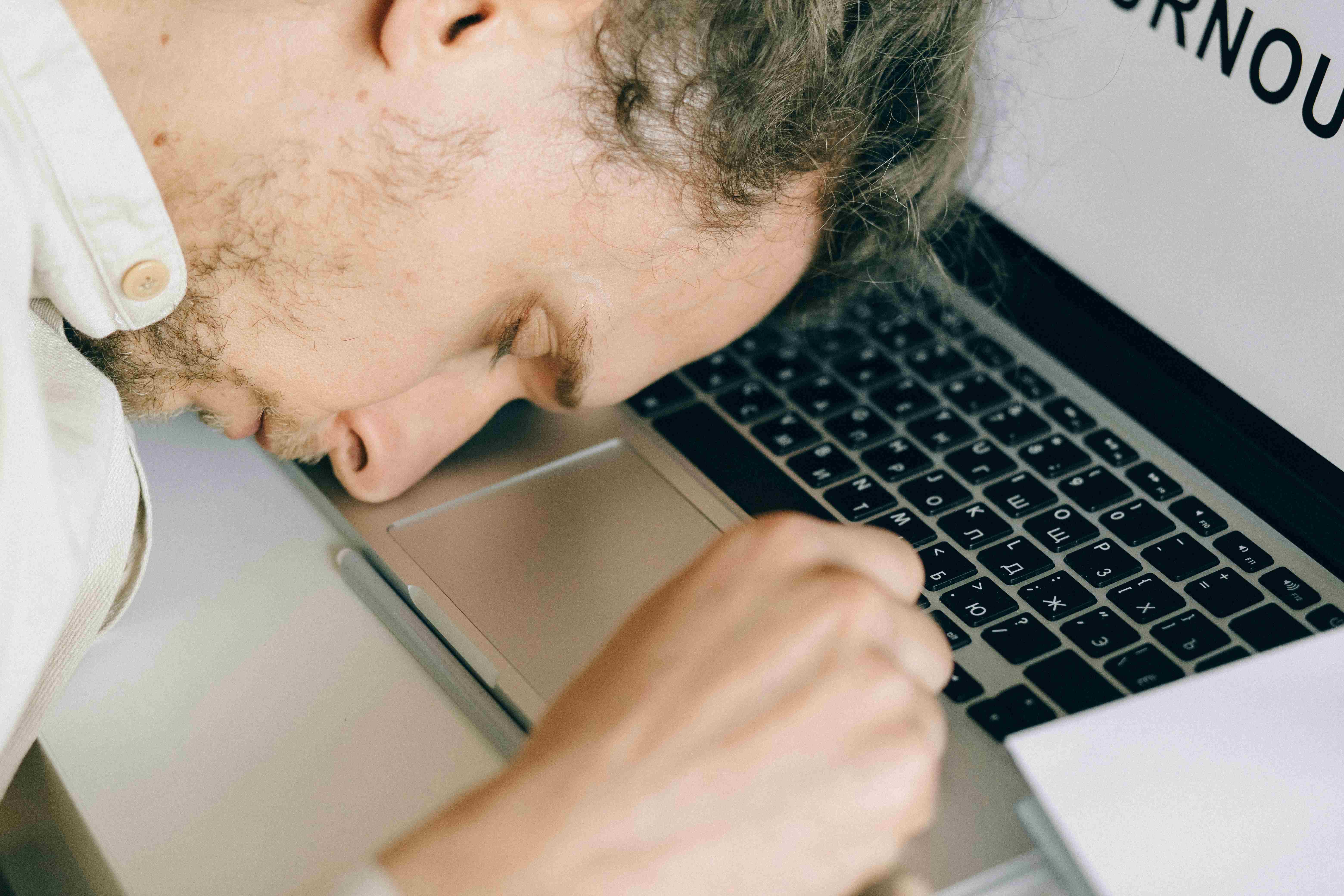ilustrasi orang yang terlihat kelelahan di depan laptop