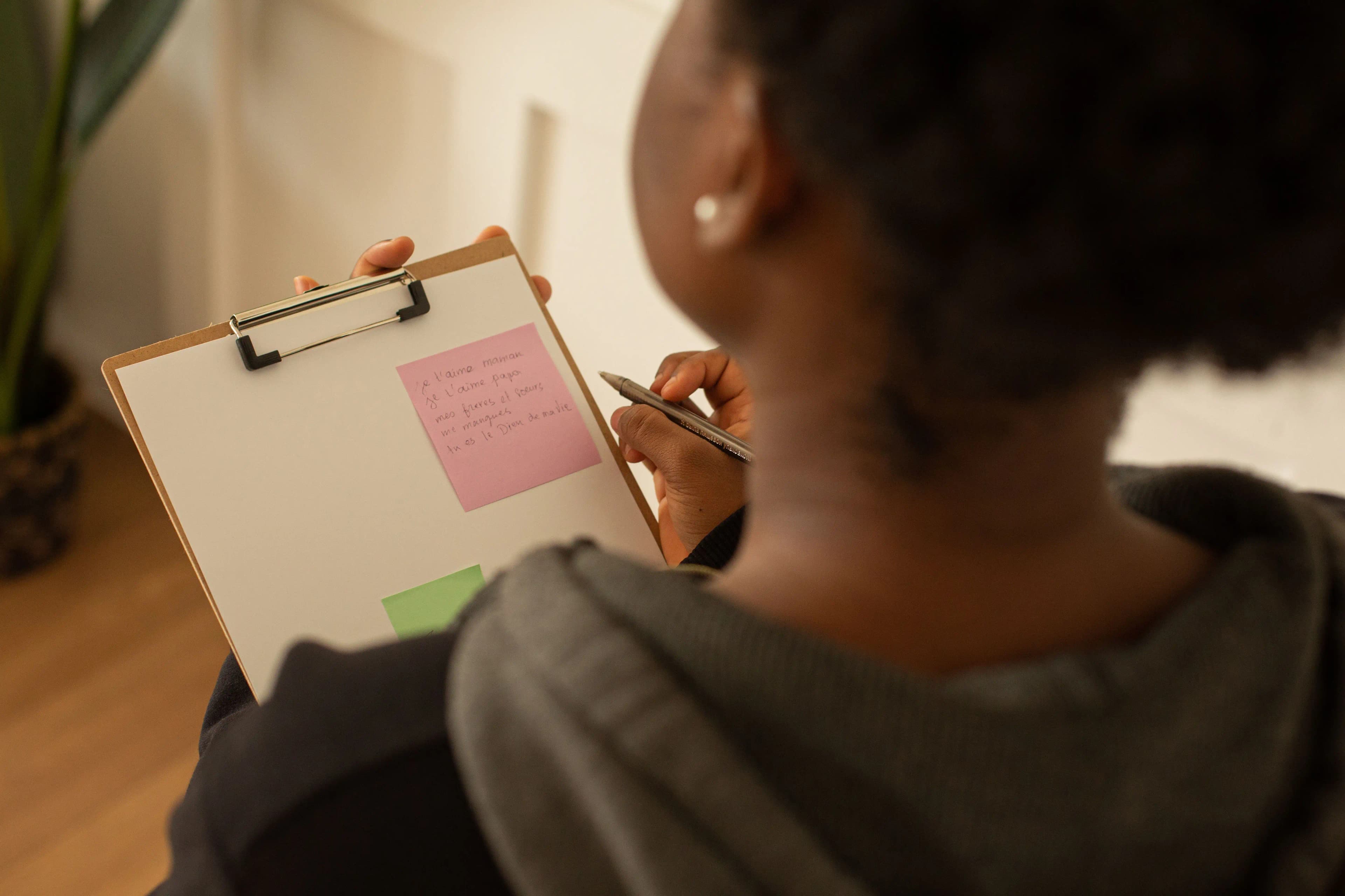 ilustrasi seorang wanita menulis catatan di clipboard dengan sticky notes berwarna-warni