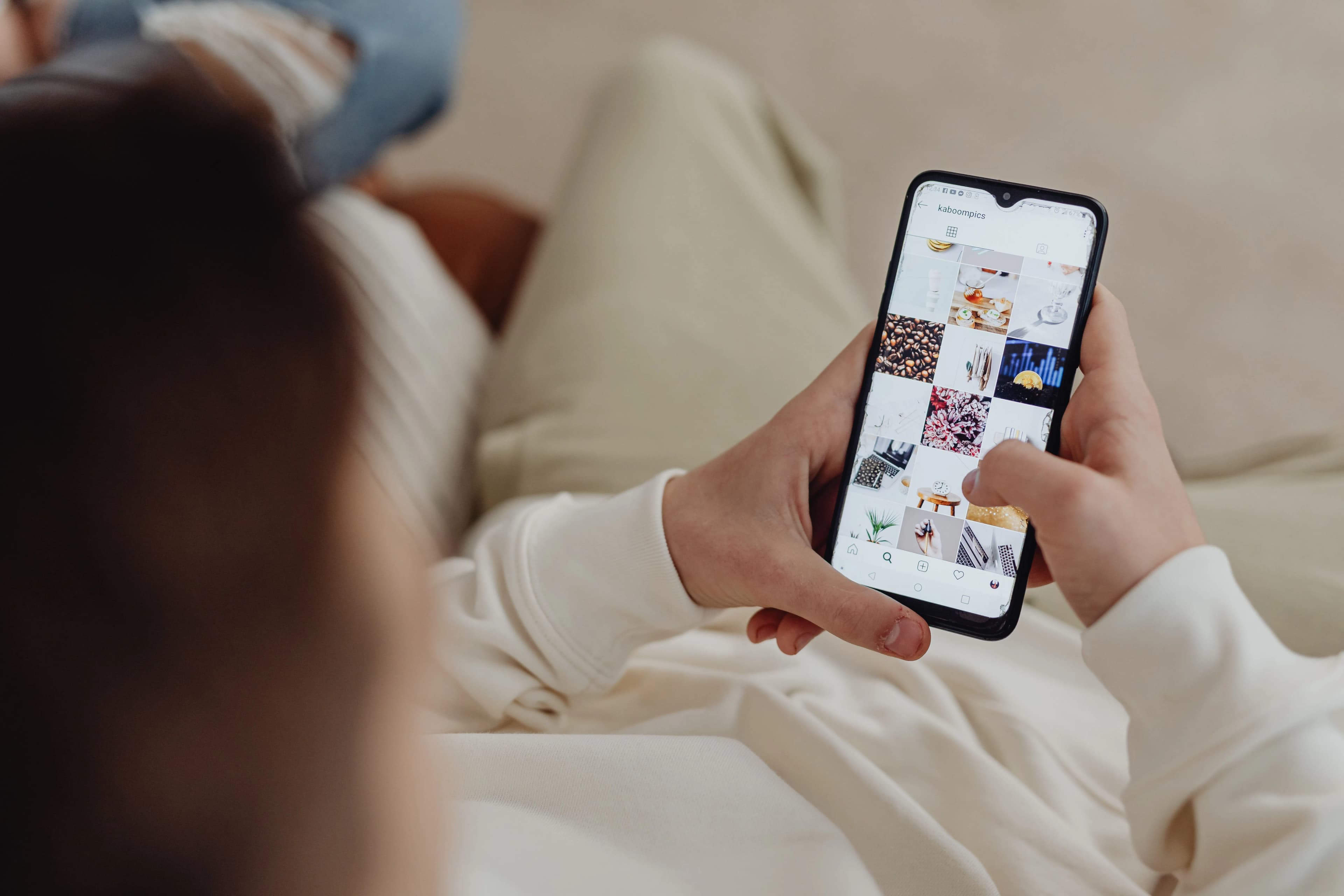 ilustrasi orang menggunakan smartphone untuk membuka Instagram di dalam ruangan, menunjukkan keterlibatan di media sosial